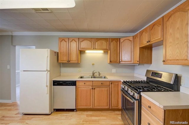 kitchen featuring light wood-type flooring, stainless steel appliances, crown molding, and sink