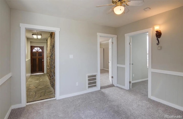 spare room featuring light carpet and ceiling fan