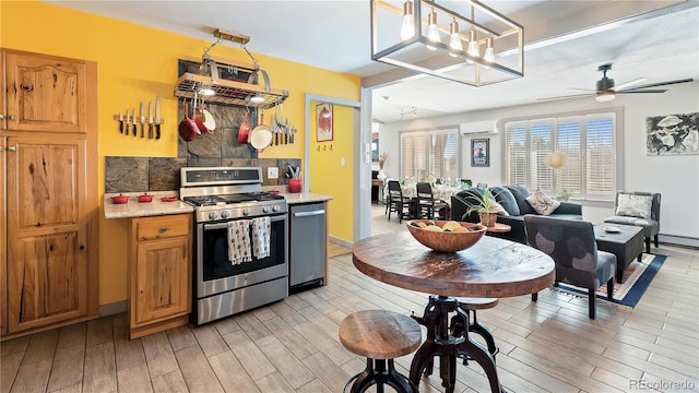 kitchen featuring a baseboard radiator, light countertops, appliances with stainless steel finishes, light wood-type flooring, and a wall mounted air conditioner