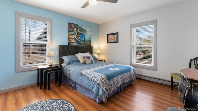 bedroom with ceiling fan, baseboards, baseboard heating, and wood finished floors