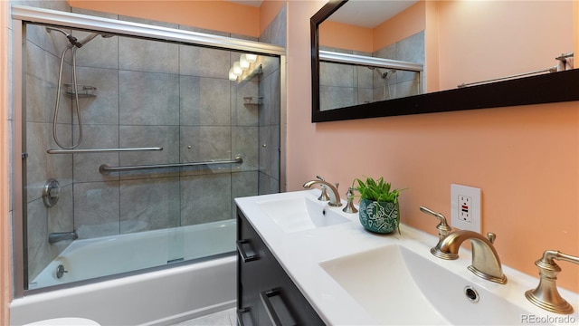 bathroom with double vanity, a sink, and bath / shower combo with glass door