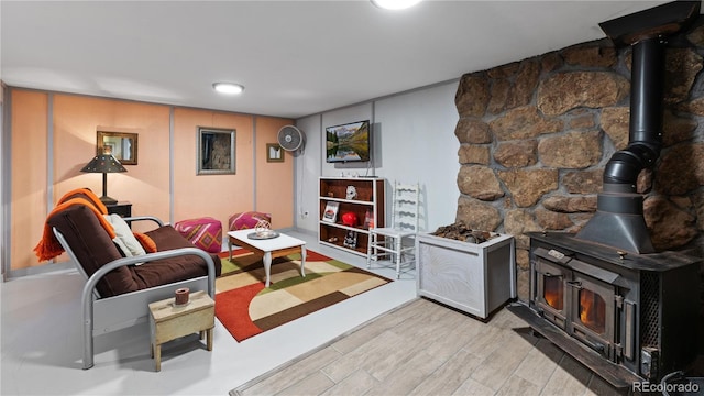 living area with a wood stove and light wood-type flooring