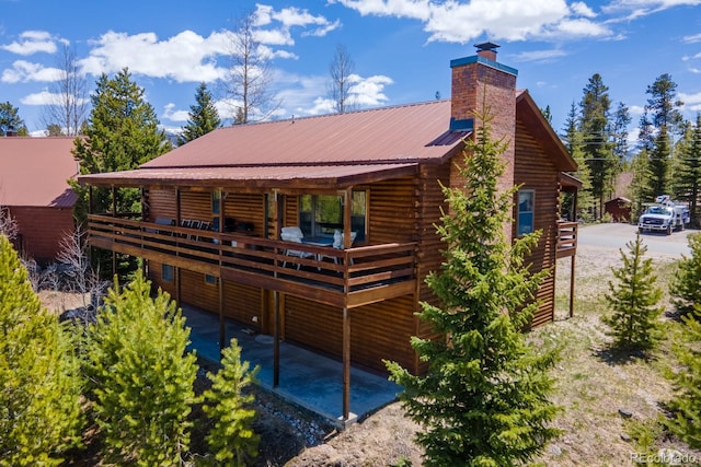 1295 Gcr 49, Grand Lake, CO 80447 - back of property featuring a chimney, metal roof, a deck, and log exterior