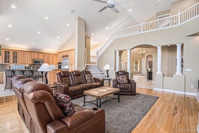 11065 W Rockland Dr, Littleton, CO 80127 - living area featuring decorative columns, high vaulted ceiling, arched walkways, light wood-style flooring, and a ceiling fan