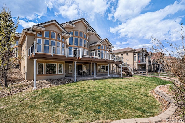 11065 W Rockland Dr, Littleton, CO 80127 - back of property with a wooden deck, stucco siding, a patio, and stairs