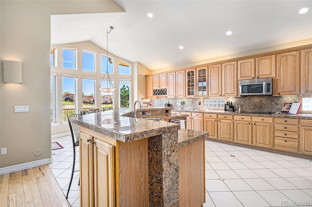 11065 W Rockland Dr, Littleton, CO 80127 - kitchen with stainless steel appliances, a sink, a kitchen bar, tasteful backsplash, and vaulted ceiling