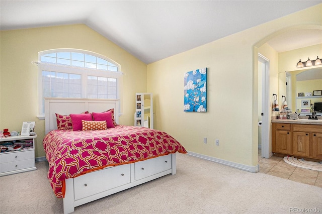 11065 W Rockland Dr, Littleton, CO 80127 - bedroom featuring light carpet, lofted ceiling, baseboards, ensuite bath, and a sink