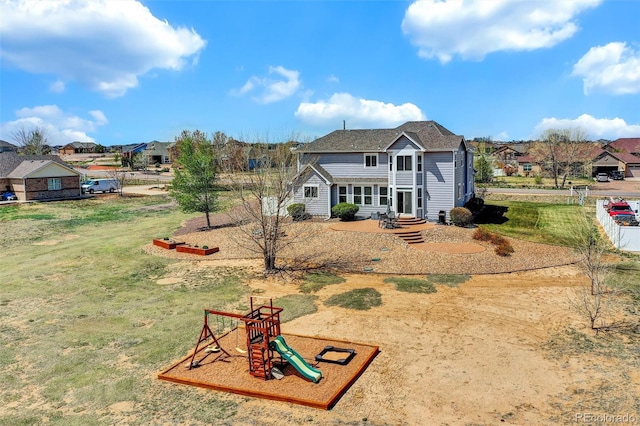 rear view of house featuring a playground, a yard, and a residential view