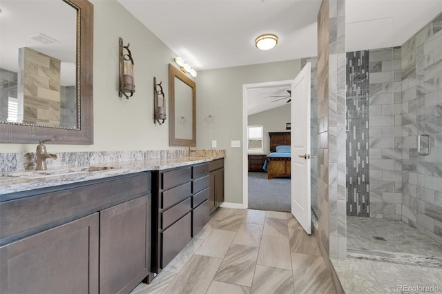 full bath with a tile shower, a sink, double vanity, marble finish floor, and ensuite bathroom