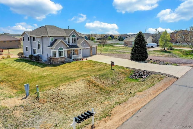 traditional home with an attached garage, concrete driveway, and a front yard