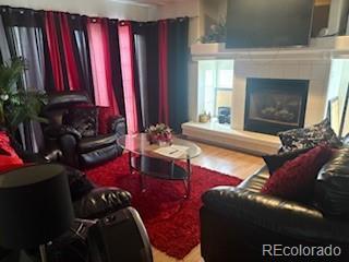 19939 Mitchell Cir, Denver, CO 80249 - living room featuring wood finished floors and a fireplace