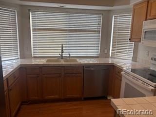 19939 Mitchell Cir, Denver, CO 80249 - kitchen featuring white appliances, wood finished floors, and tile counters