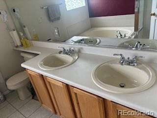 19939 Mitchell Cir, Denver, CO 80249 - full bathroom featuring tile patterned floors, double vanity, and a bath
