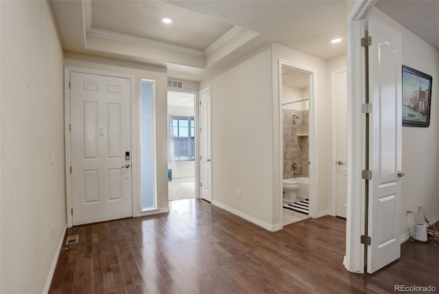 entryway featuring dark hardwood / wood-style floors, crown molding, and a tray ceiling