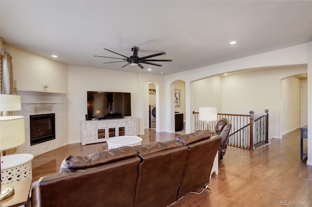 living room featuring wood-type flooring, washer / clothes dryer, and ceiling fan