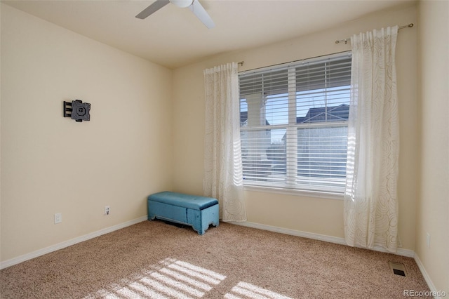 carpeted spare room featuring ceiling fan