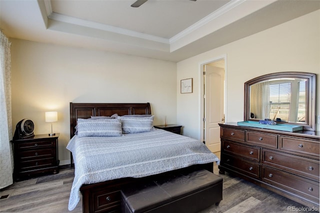 bedroom with ceiling fan, wood-type flooring, crown molding, and a tray ceiling