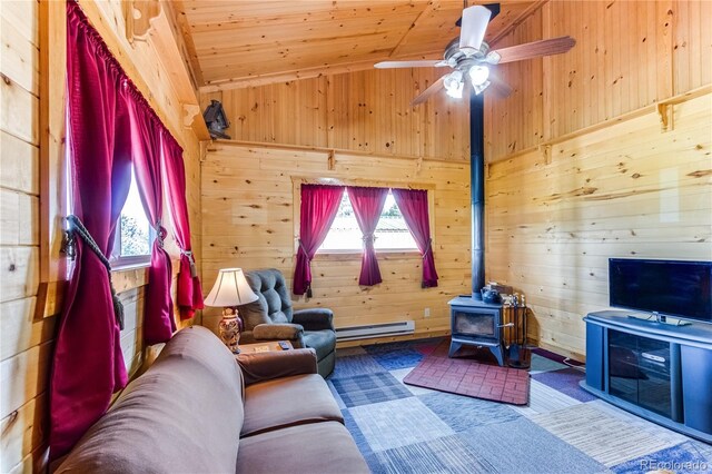 62 Rubel Cir, Westcliffe, CO 81252 - living room featuring a baseboard heating unit, wooden walls, a wood stove, wooden ceiling, and a ceiling fan