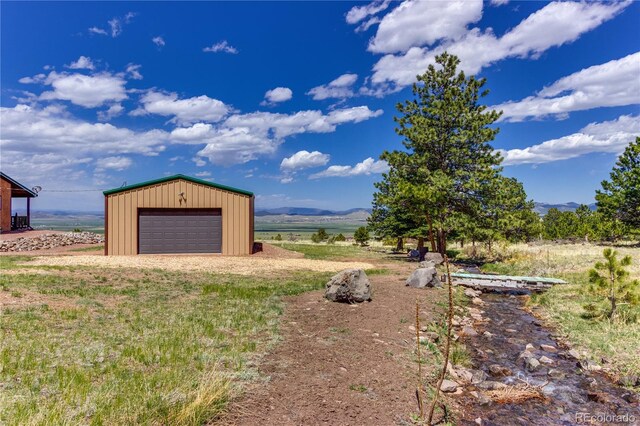 62 Rubel Cir, Westcliffe, CO 81252 - view of yard with a garage, an outdoor structure, driveway, and a mountain view