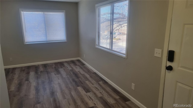 spare room featuring dark wood-type flooring and a healthy amount of sunlight