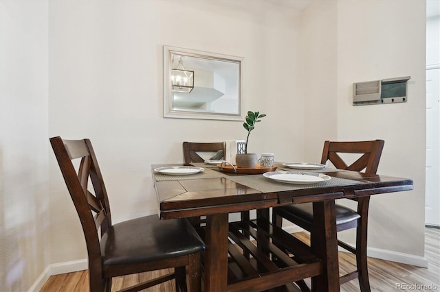 dining room featuring an inviting chandelier and light hardwood / wood-style flooring