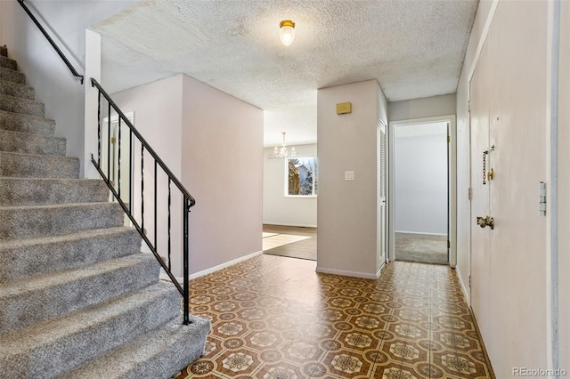 foyer featuring a notable chandelier and a textured ceiling