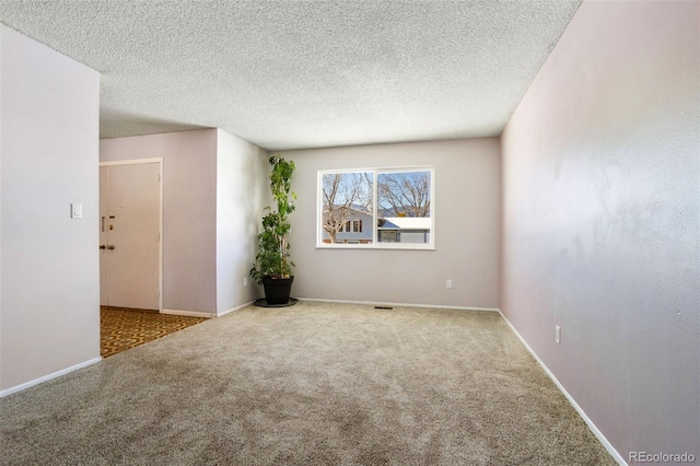 spare room featuring carpet and a textured ceiling