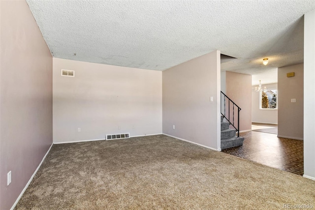 empty room with an inviting chandelier and dark carpet