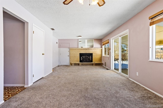 unfurnished living room with a fireplace, a textured ceiling, carpet floors, and ceiling fan