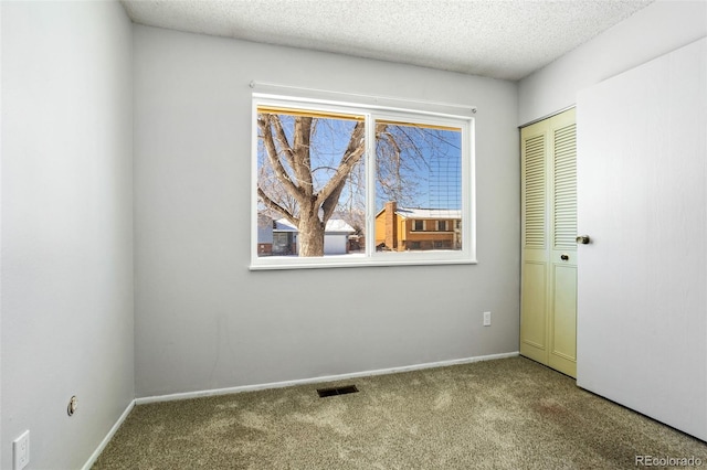 carpeted spare room featuring a textured ceiling