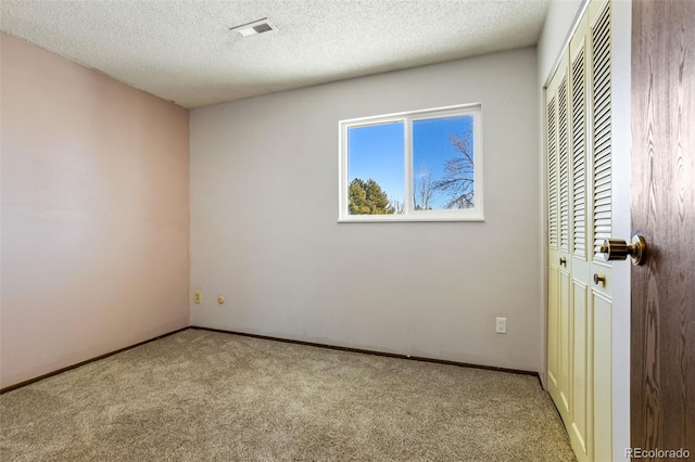 interior space with light carpet and a textured ceiling