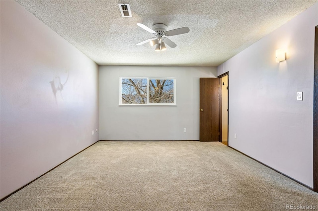 carpeted empty room with ceiling fan and a textured ceiling