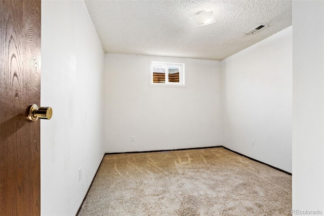 unfurnished room with a textured ceiling and carpet