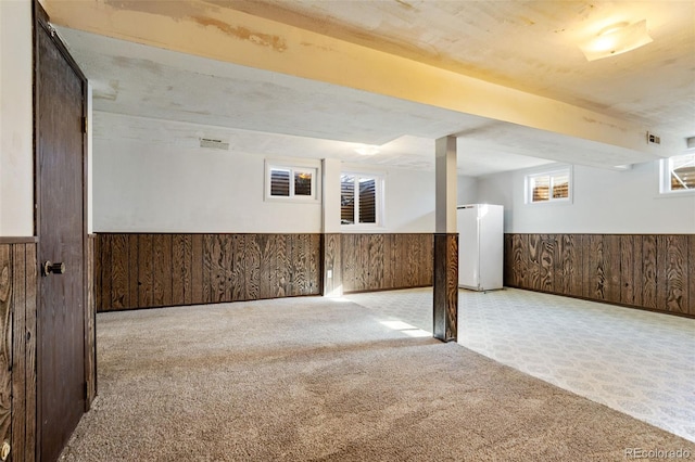 basement with light carpet and white refrigerator