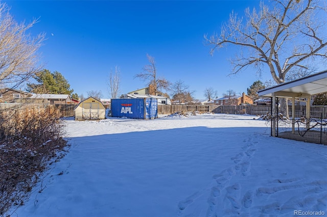 yard layered in snow with a storage shed