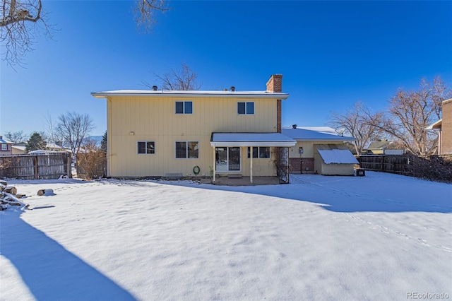 view of snow covered rear of property