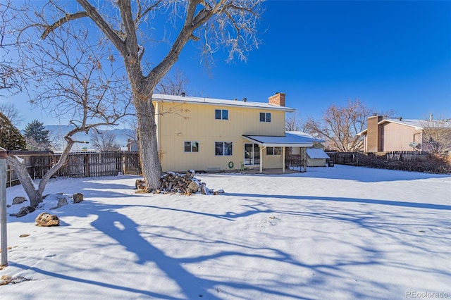 view of snow covered rear of property