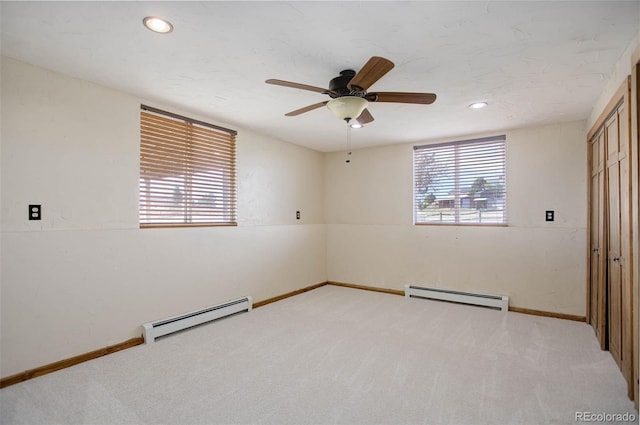 carpeted empty room with a baseboard radiator and ceiling fan