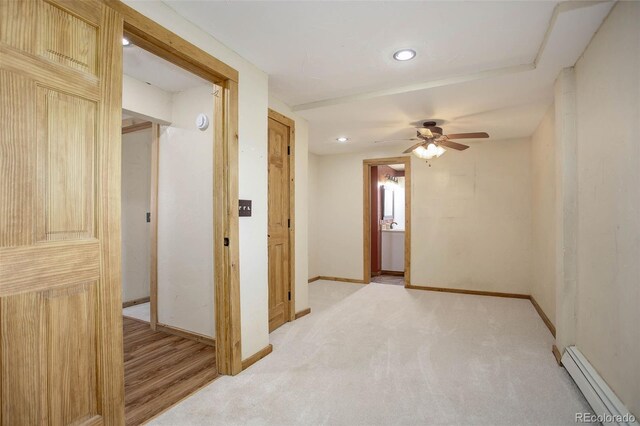 corridor featuring light carpet and a baseboard heating unit