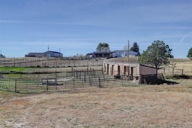 view of yard with a rural view and an outdoor structure