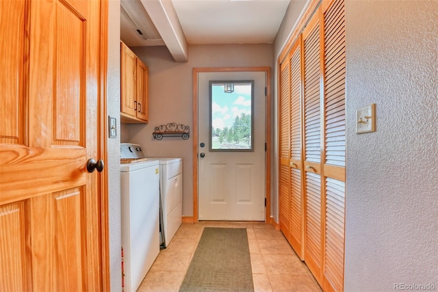 laundry area featuring light tile patterned floors, cabinets, and independent washer and dryer