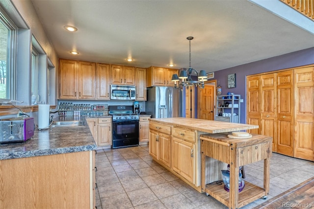 kitchen with stainless steel appliances, light tile patterned floors, an inviting chandelier, pendant lighting, and a kitchen island