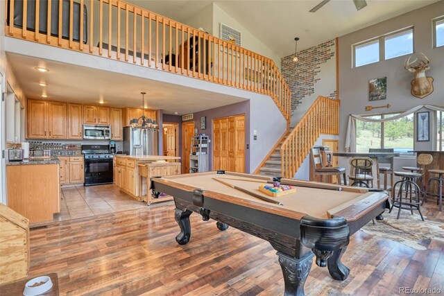 game room with high vaulted ceiling, ceiling fan, light wood-type flooring, and pool table