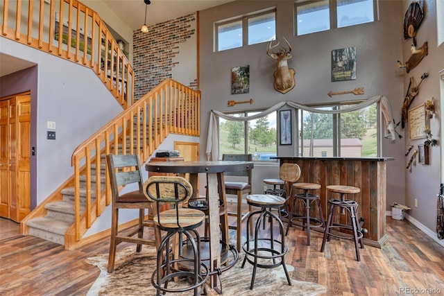 bar featuring hardwood / wood-style floors and a high ceiling