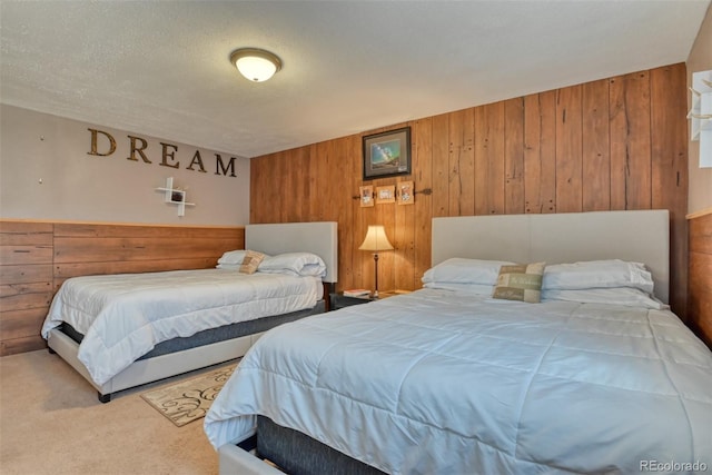 carpeted bedroom with wood walls and a textured ceiling