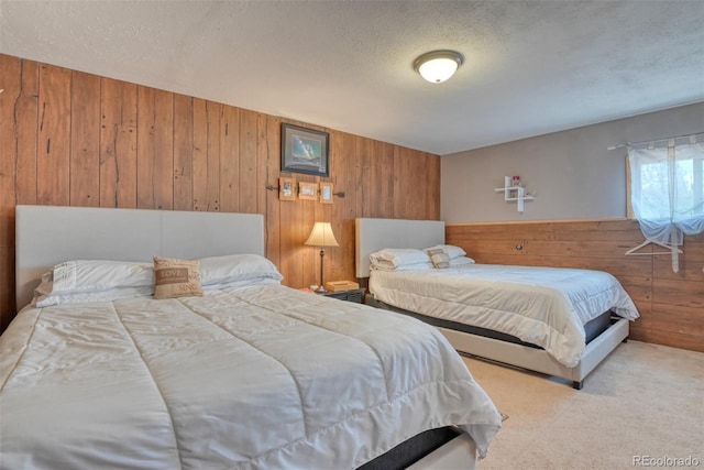 carpeted bedroom with a textured ceiling and wooden walls