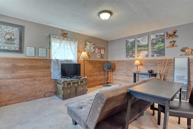 carpeted living room featuring wood walls and a textured ceiling