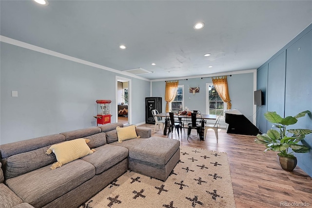 living room with crown molding and light wood-type flooring