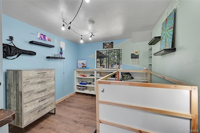 bedroom with a textured ceiling and hardwood / wood-style flooring