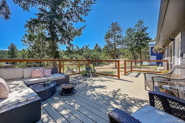 wooden deck featuring an outdoor living space with a fire pit